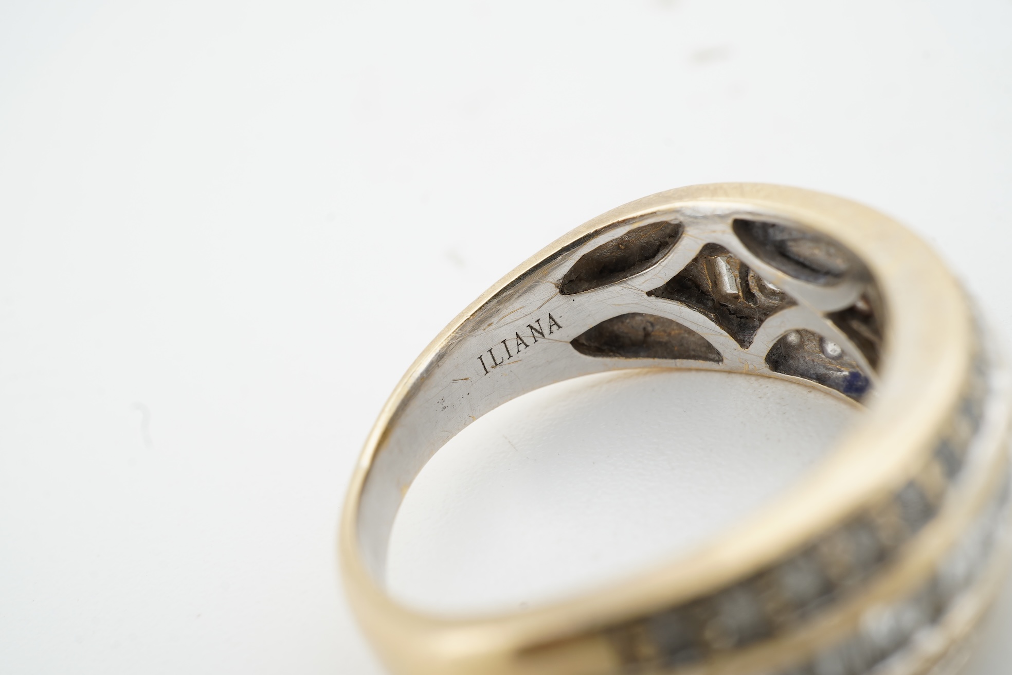 A diamond ring, the wide band set with a line of alternating brilliant-cut and baguette diamonds, between bands of brilliant-cut diamonds, mounted in gold, size M, British hallmarks for 18ct gold, total diamond weight ap